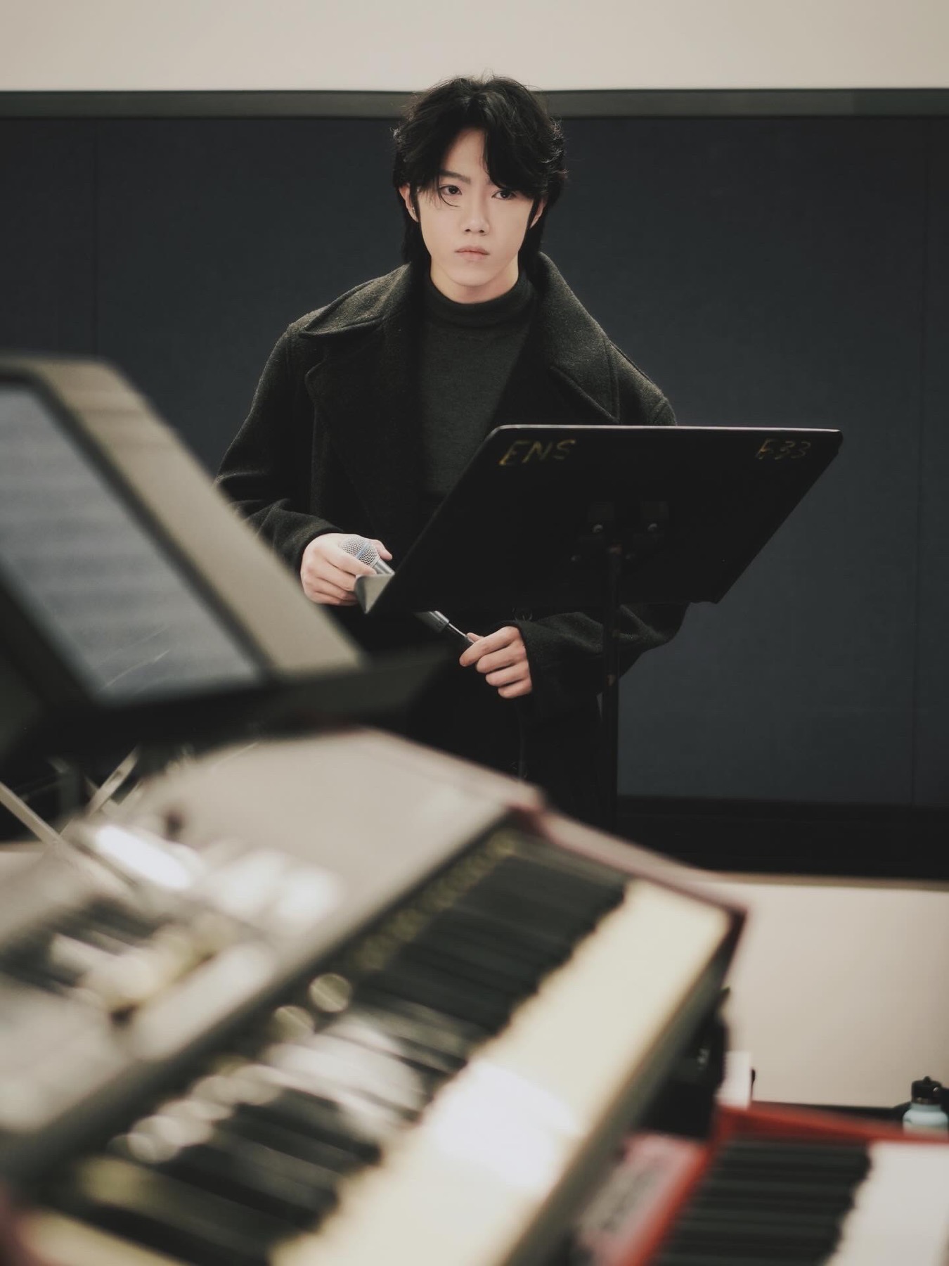 Wayne Wen holding a microphone during a rehearsal